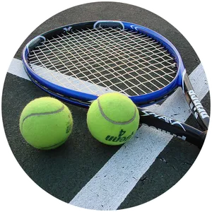 Two tennis balls laying next to a racket